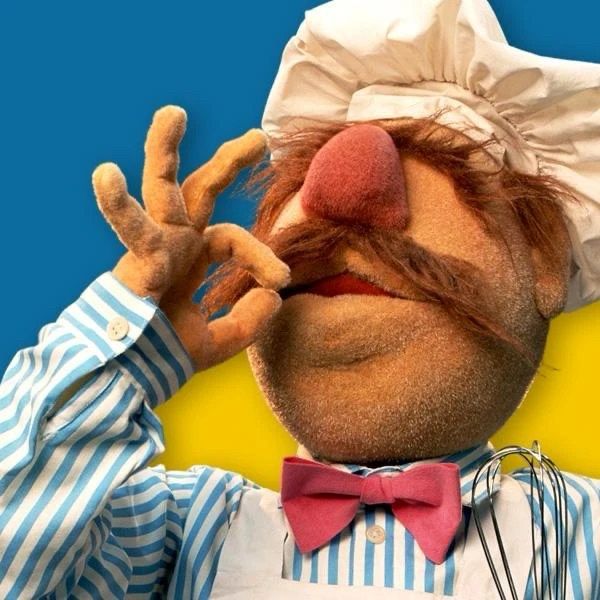 Muppets character Swedish chef holding his fingers to his lips and doing the classic kissing delicious noise