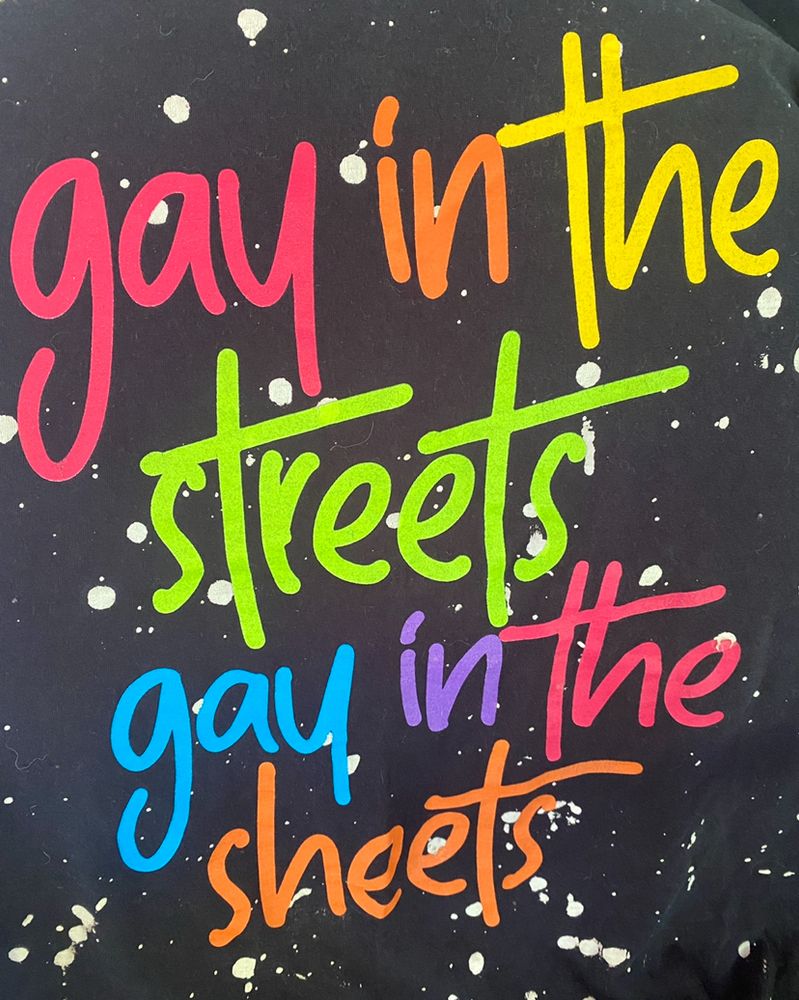Today’s rainbow lettering pride shirt reads: 
“gay in the 
streets 
gay in the
sheets”

On a black background white white paint splatters