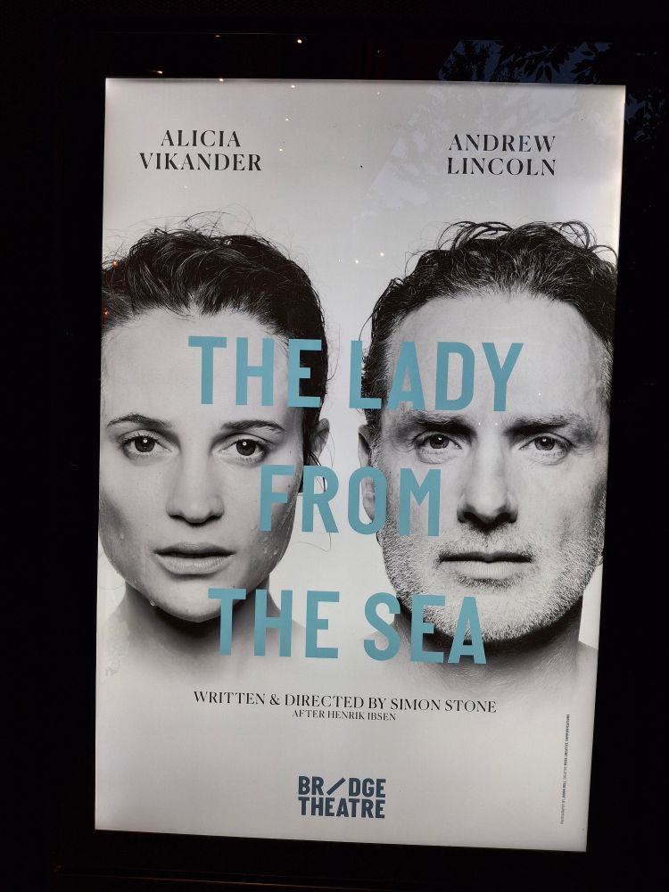 Black and white theater poster with the faces of Alicia Vikander and Andrew Lincoln. Written over them in blue "The Lady from the sea".