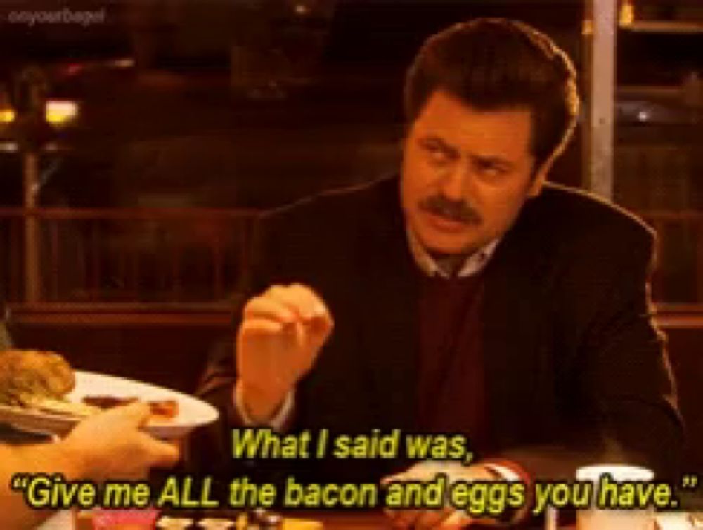 a man is sitting at a table eating bacon and eggs and says " give me all the bacon and eggs you have