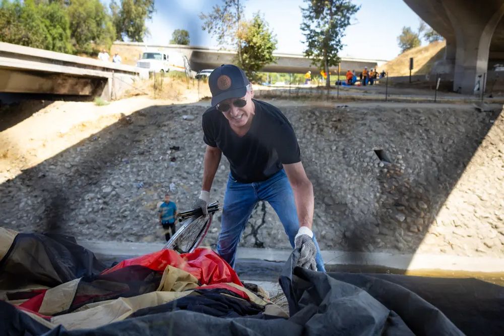 gavin newsom gleefully destroying a homeless person's only possessions with his own hands for press