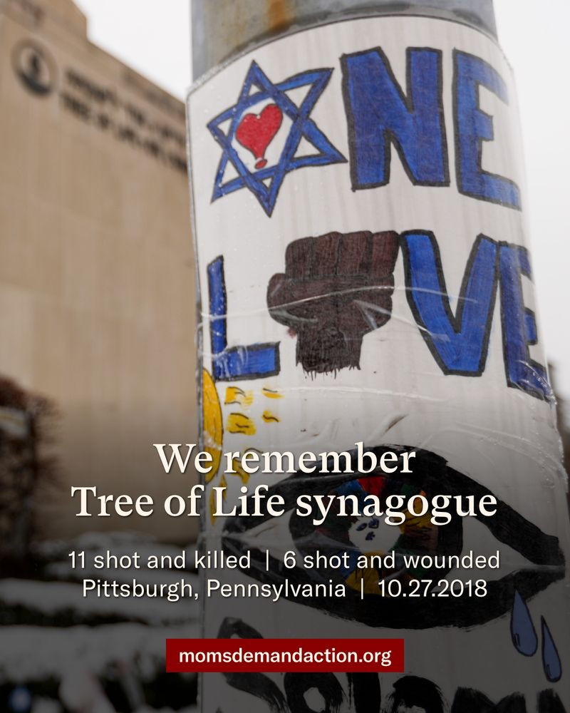 An image of the Tree of Life synagogue with a handmade memorial poster in the foreground with text that says, “We remember Tree of Life synagogue, 11 shot and killed, 6 shot and wounded, Pittsburgh, Pennsylvania, October 27, 2018 momsdemandaction.org”
