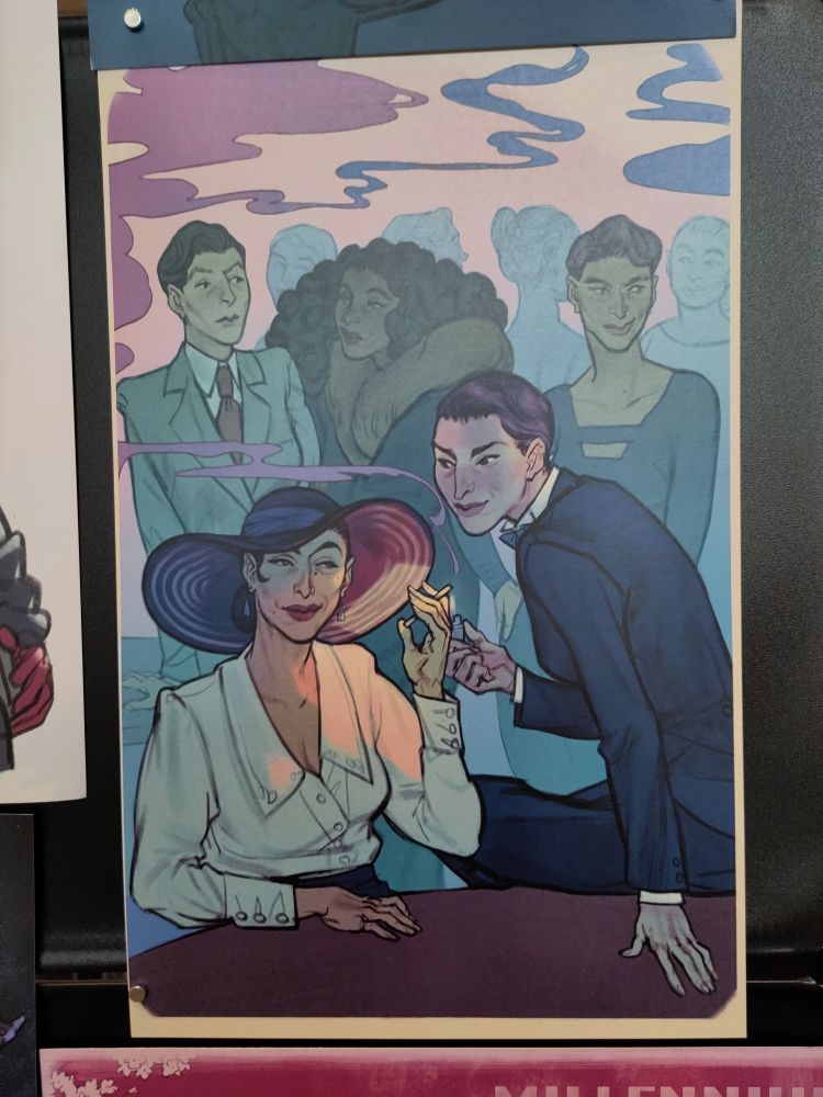 A picture of my print of women in a bar. In the front a woman sits on the table and lights a cigarette for another woman. 