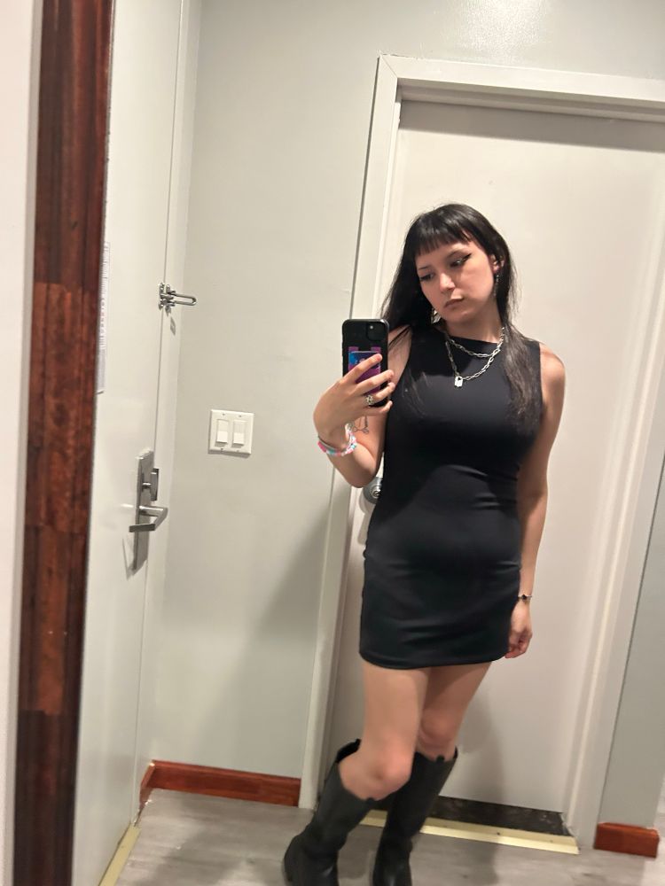 Aria mirror selfie in hotel room, wearing cute black dress and boots