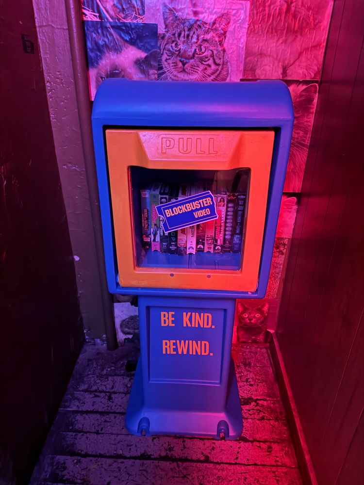 At the top of the stairs theirs a tiny blockbuster video library with vhs tapes in it