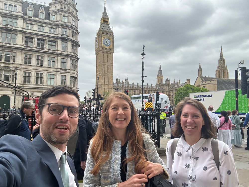 Three people smiling in the street in London