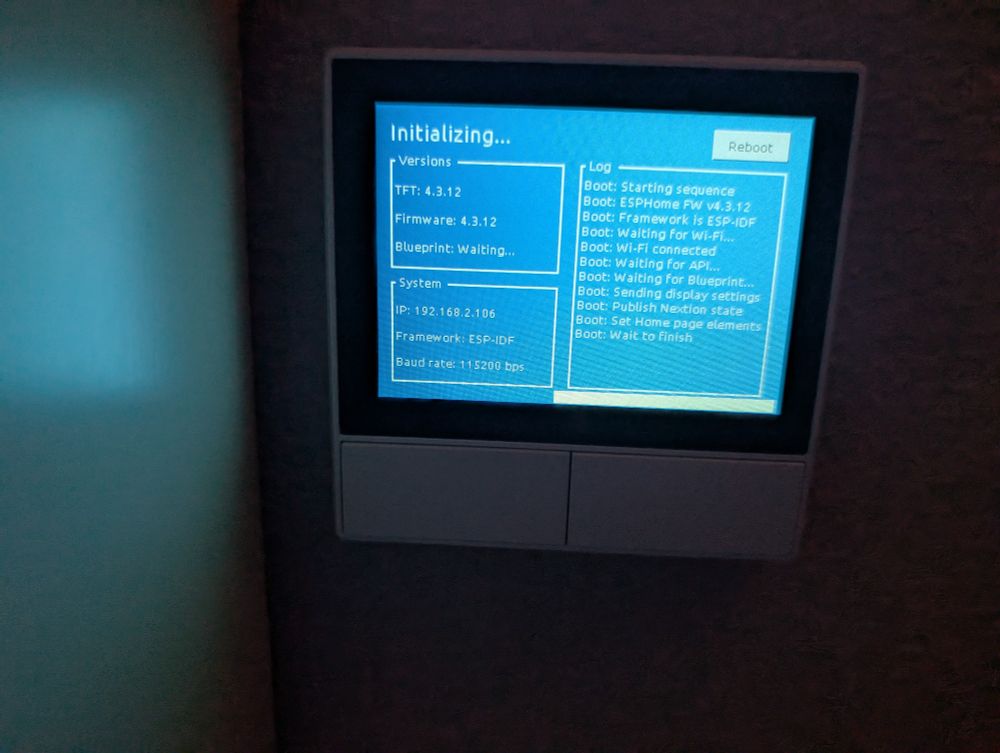 Light switch with a built-in LCD panel showing a boot sequence.
