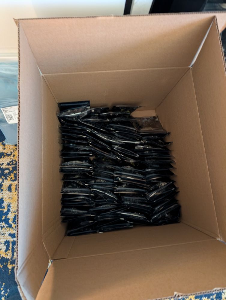 A picture of a box with the bottom mostly filled with electrostatic bags full of kit parts 