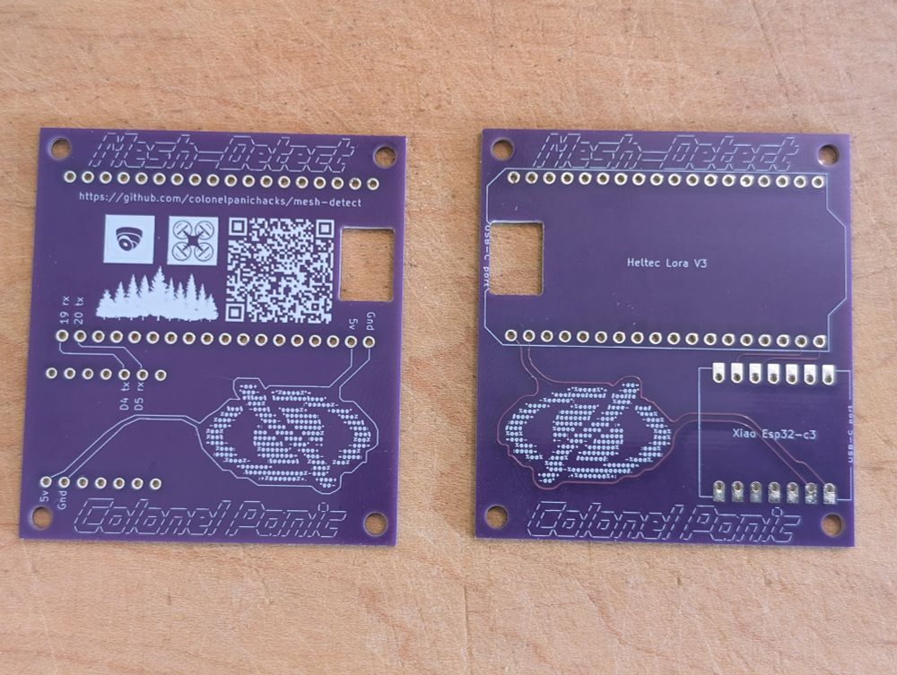 Two PCBs on a wooden surface; they are arranged to show the top and the bottom. There is a QR code to a GitHub project 