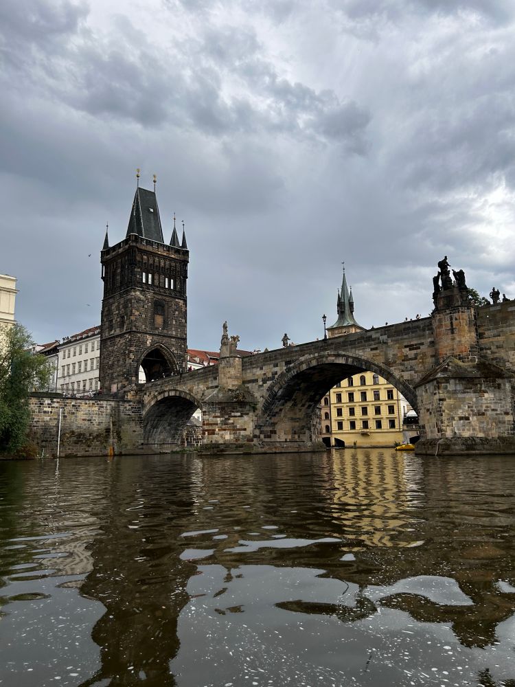 Das Eingangstor zur Karlsbrücke in Prag, fotografiert vom fahrenden Boot auf der Moldau.