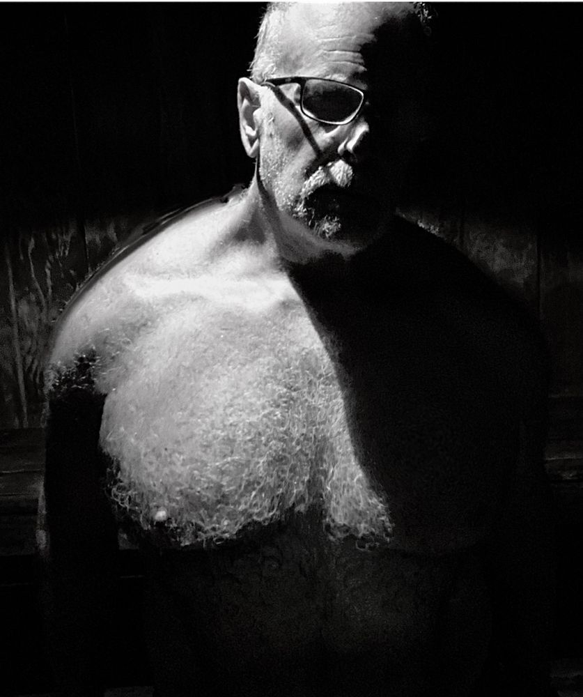 Sauna selfie with one pec in the shadows again, the other lit from over the shoulder.