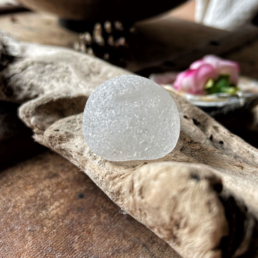 The same dome shaped white seaglass flipped over to show its curved bottom