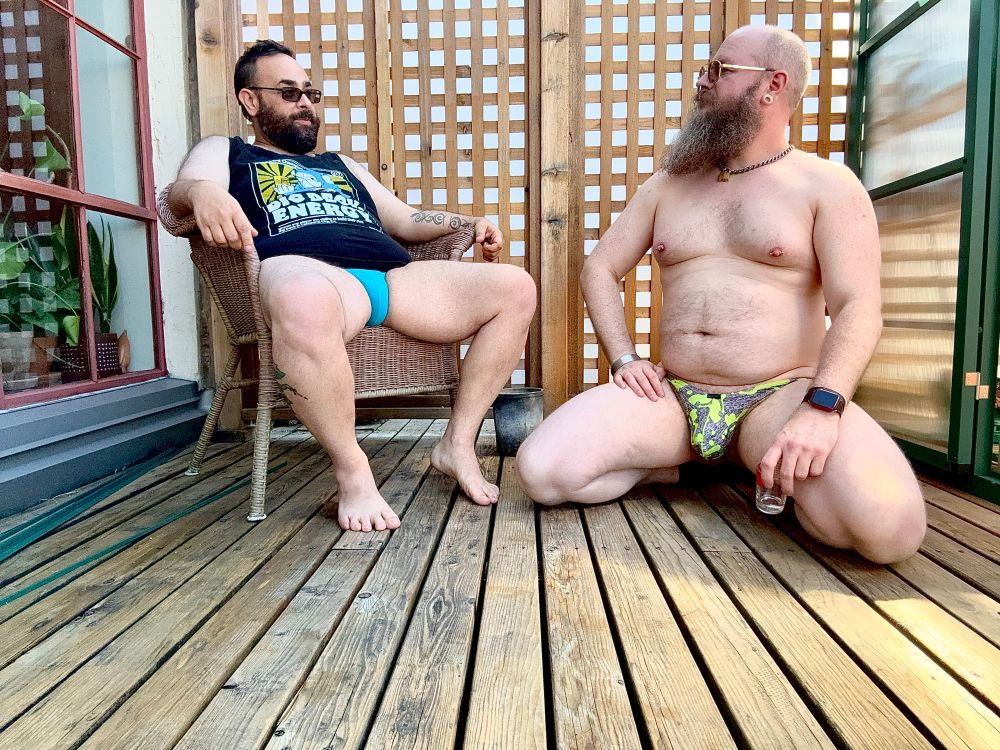 Two men sitting out on the deck enjoying a conversation 