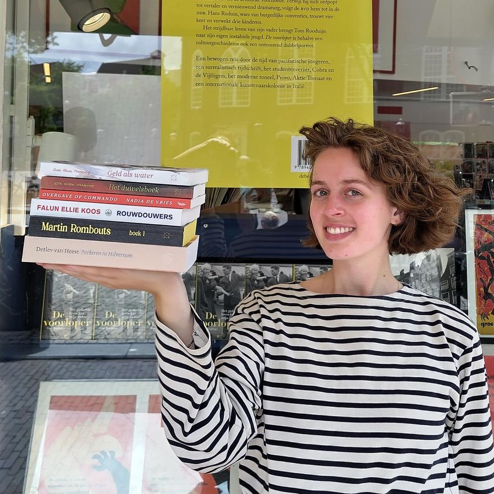 Boekverkoper Lotte Bosch met romans over werk, geld(tekort) en klasse, van Anton Valens, Detlev van Heest, Falun Ellie Koos, Martin Rombouts en Nadia de Vries. Bij Athenaeum Boekhandel Spui.