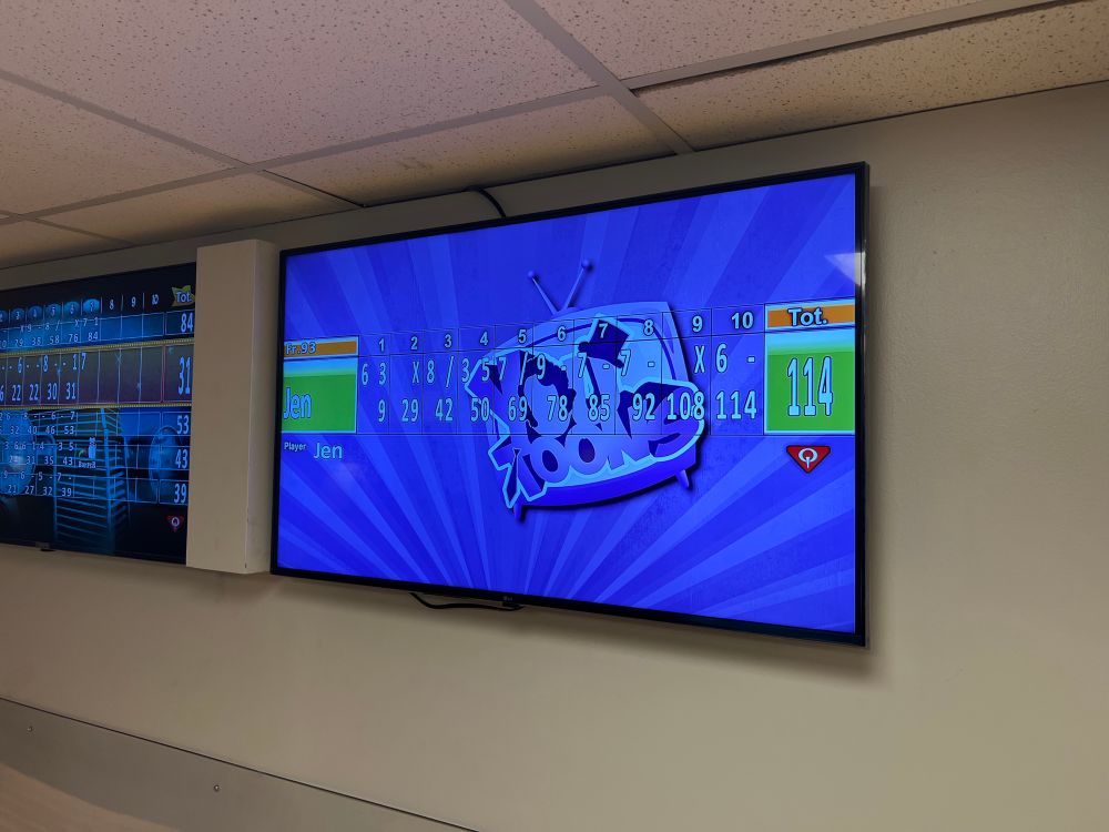 A photo of a tv showing a bowling scoreboard with one player named Jen scoring a total of 114 points.