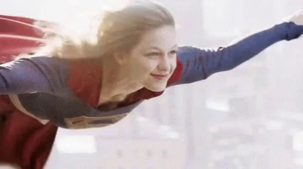 a woman dressed as superman is flying through the air .