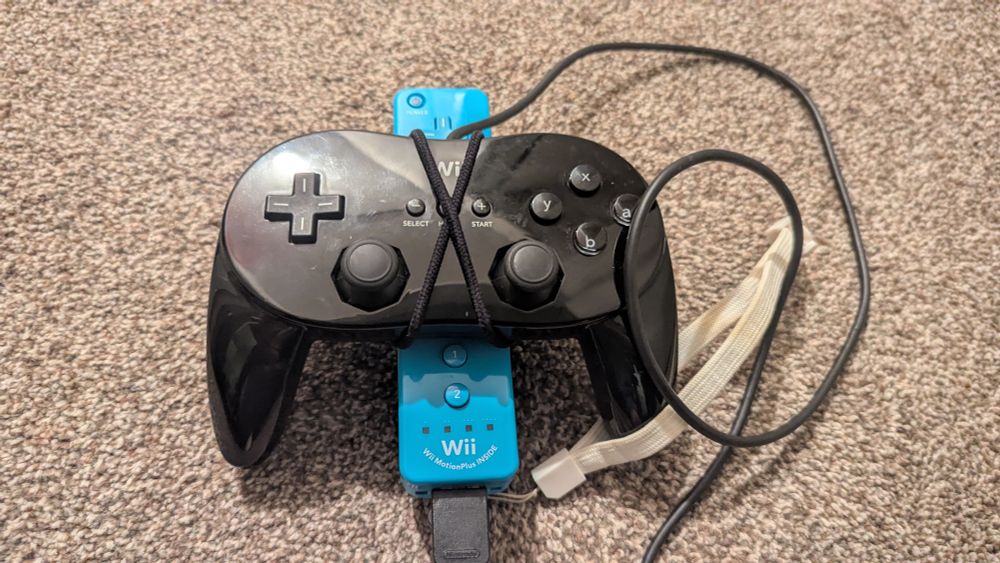 A Wii Classic Controller Pro tied to a Wii Remote using hair bands, an official solution to use motion aim in the battle dojo in Splatoon 1.
