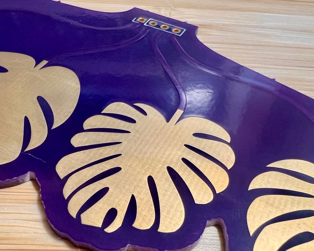 A close up of one capacitive touch pad Monstera leaf and some curved PCB traces.