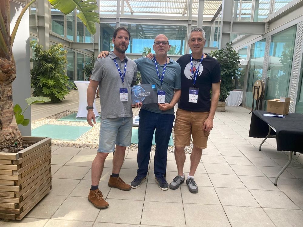 Three scientists pose together indoors at the INCISE symposium, one holding an award plaque; all wear name tags and symposium lanyards.



Pictured left to right: Fabio De Leo, Claudio Lo Iacono, Pere Puig