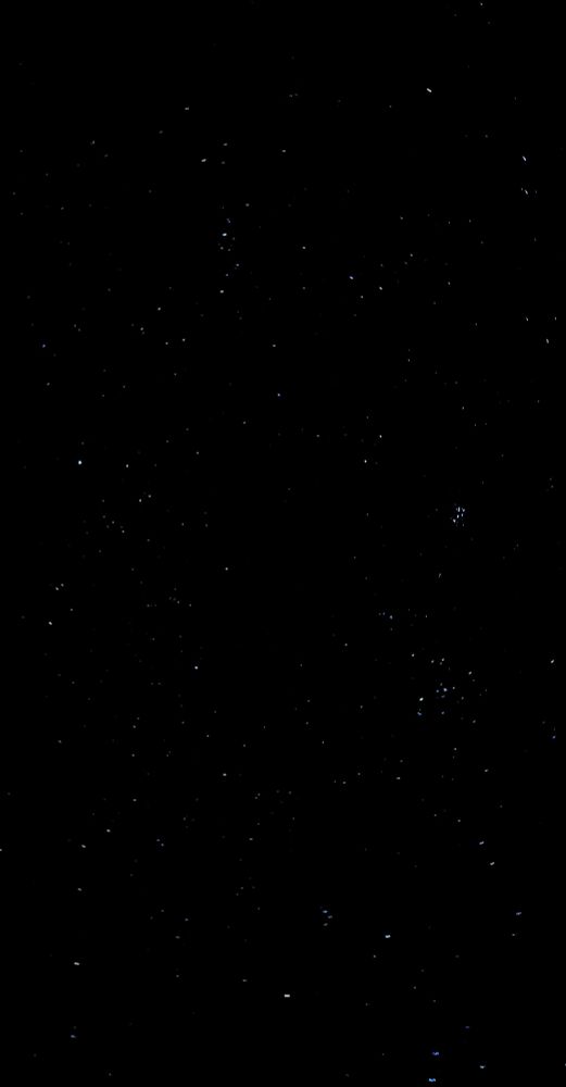 Schwarzer Nachthimmel mit unzähligen Sternen, unter anderem mit dem Sternbild des Stiers und den Plejaden.