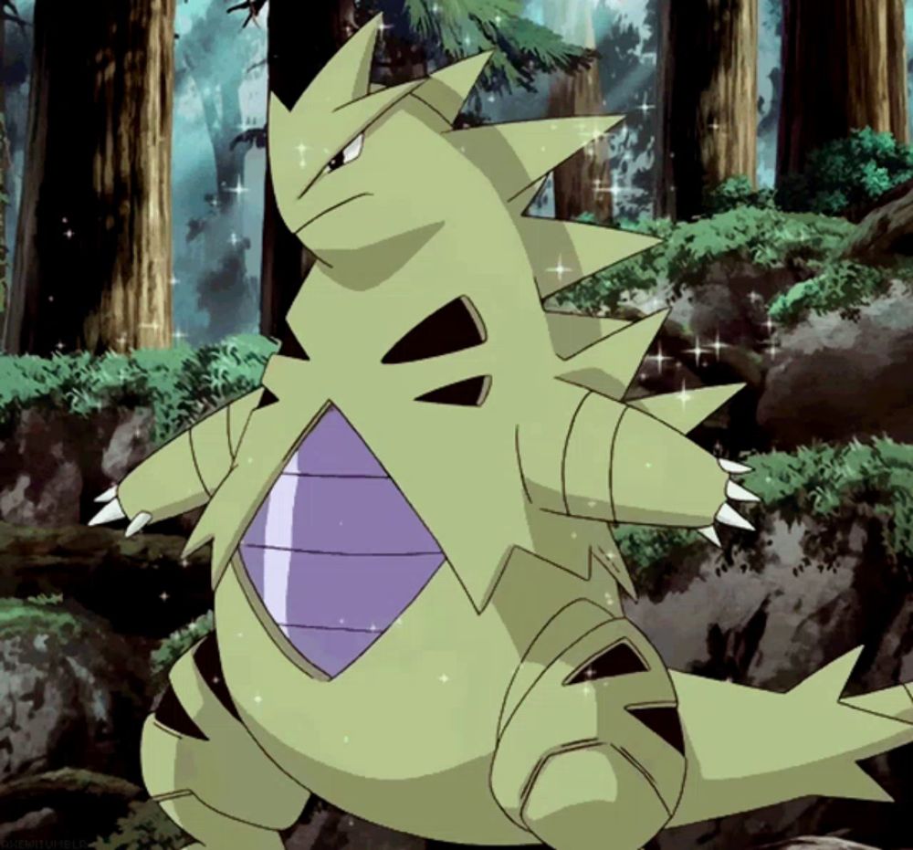 a green pokemon with a purple stripe on its chest