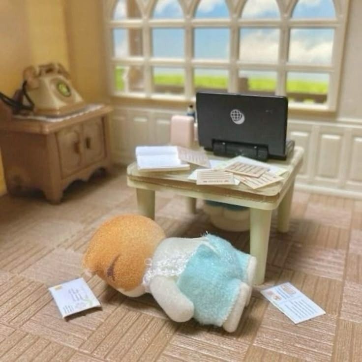 Calico critter lying face down in their nice modern office 