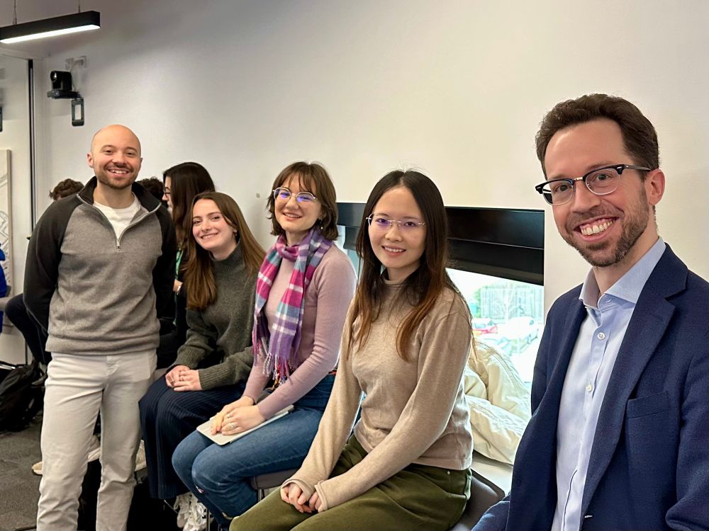 A photo of John, Natascia, Bianca, Litong, and Volker in a seminar room