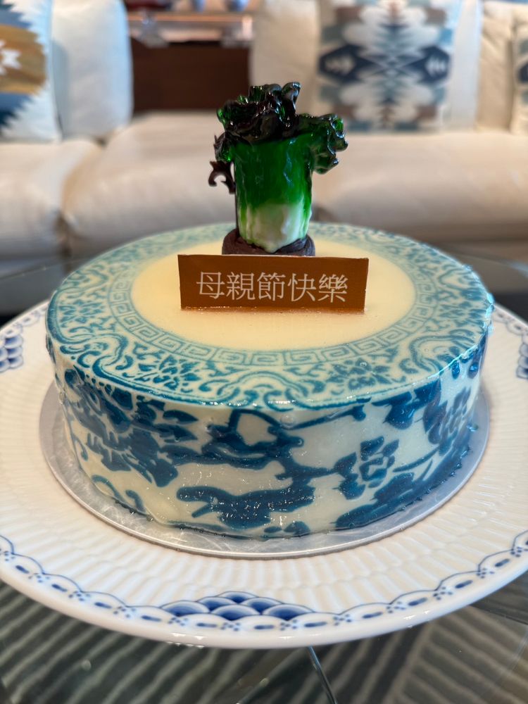 A cake with a little miniature chocolate cabbage on top