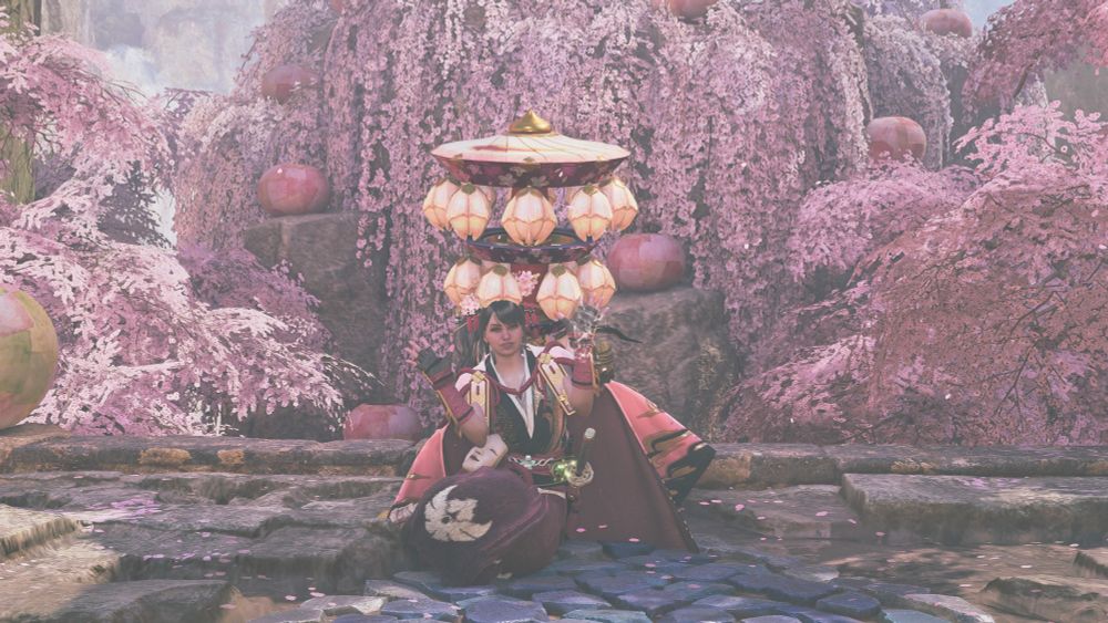 Screenshot from monster hunter wilds. Player character pictured in the center, with pink blossom trees in the background.