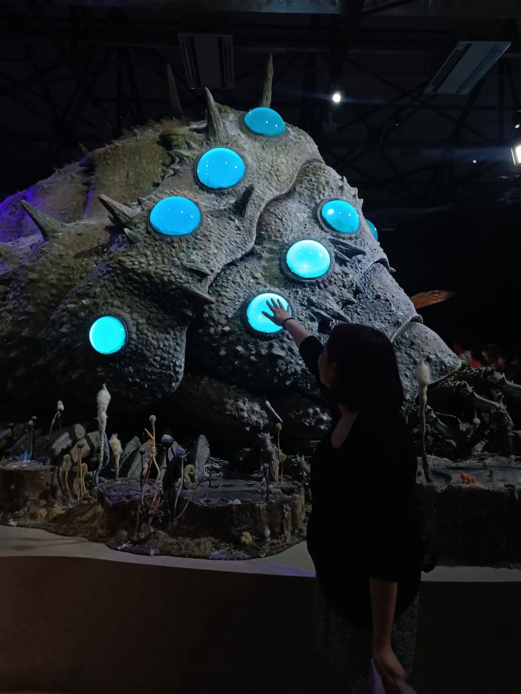 Photo showing myself reaching out towards the life-sized sculpture of Ohmu from the ghibli movie Nausicaa