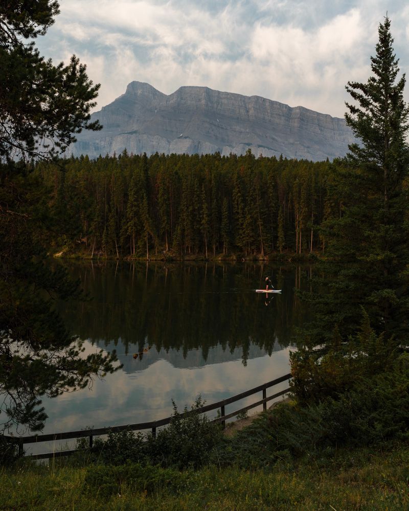 Paddle boarder on a lake in front of a mountain