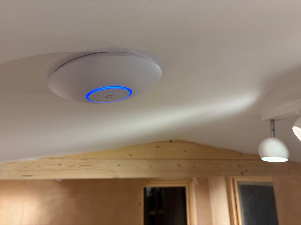 The same WiFi access point is now affixed to the ceiling. In the background are the freshly plastered walls of my shed/studio and ball-shaped spotlights.