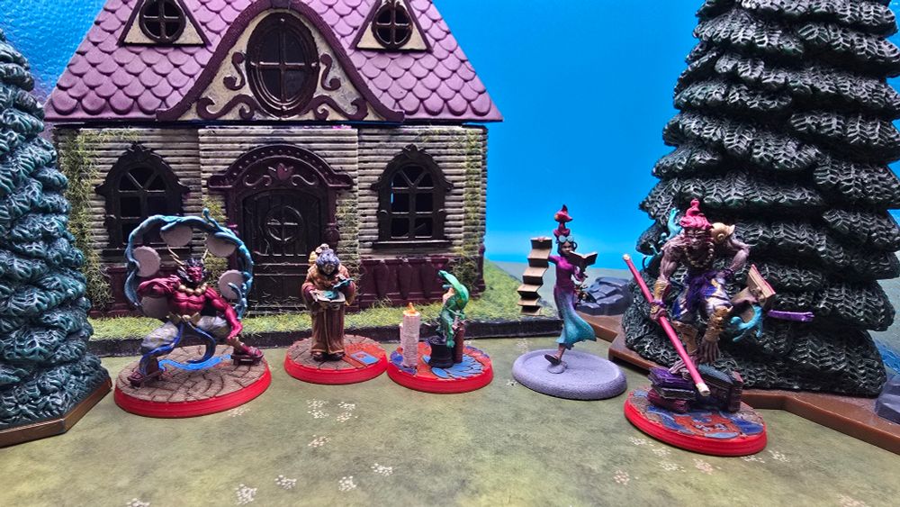 Several colorful Malifaux miniatures set up in a row. From left to right: Story of Raijin, Miya Murakami, Jade Rabbit, Linh Ly Bibliothecary, Story of Sun Wukong