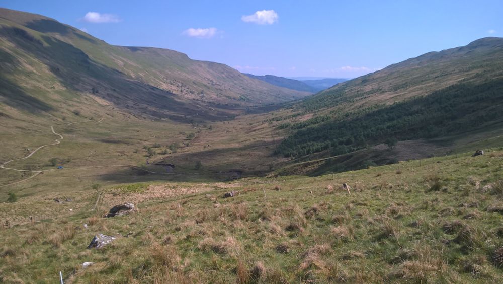 A panoramic landscape view of the glen. A single shadow is cast from the right-hand side.