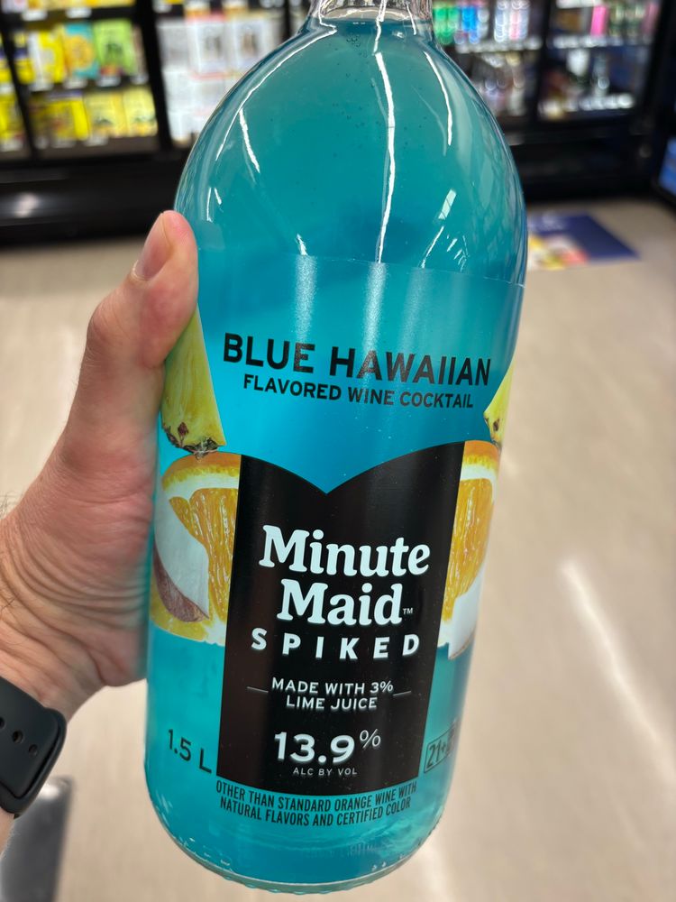 A hand holding a bottle of Minute Maid Spiked Blue Hawaiian.