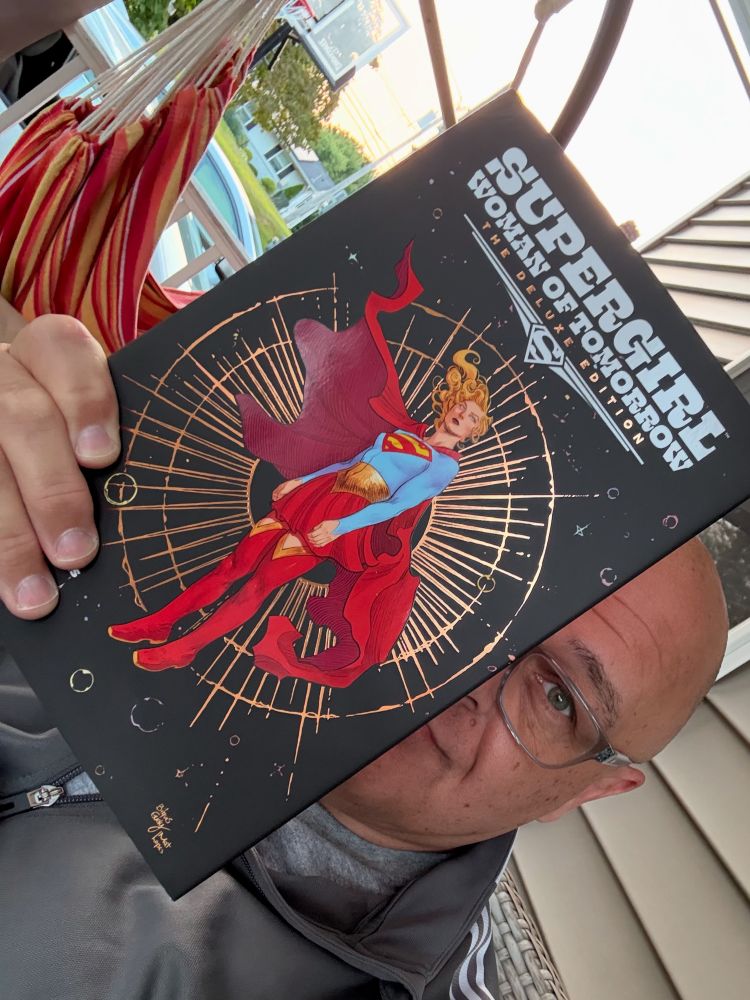 Handsome man holding the aforementioned comic, and Supergirl looks badass.