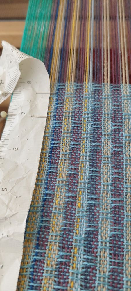 The start of a tea towel woven in huck lace.  The warp consists of randomly spaces yarns which are arranged in dark and light stripes