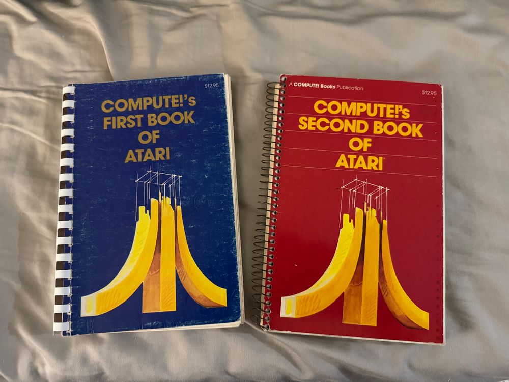 Two spiral-bound books: Compute’s First Book of Atari (blue) and Compute’s Second Book of Atari (red)