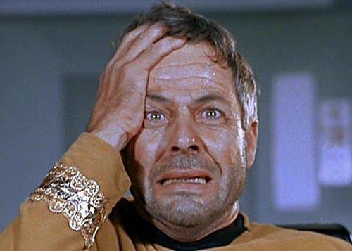 In a still from TOS: "The Doomsday Machine", Commodore Matt Decker stares directly at the camera with his right hand against his right temple. He's grimacing, obviously very distraught. Mere moments after this image, his shuttle will be engulfed and destroyed by the Doomsday Machine.