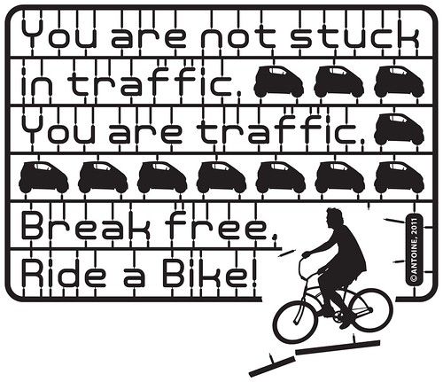 Illustration depicting the sort of bits of plastic that come with a a plastic model that you put together with glue, all held together as one unit that you have to pull apart. On this the pieces are cars, plus the words, "You are not stuck in traffic, You are traffic. Break free, Ride a Bike." In the lower right there's a picture of a person on a bike breaking free of the plastic attachments.