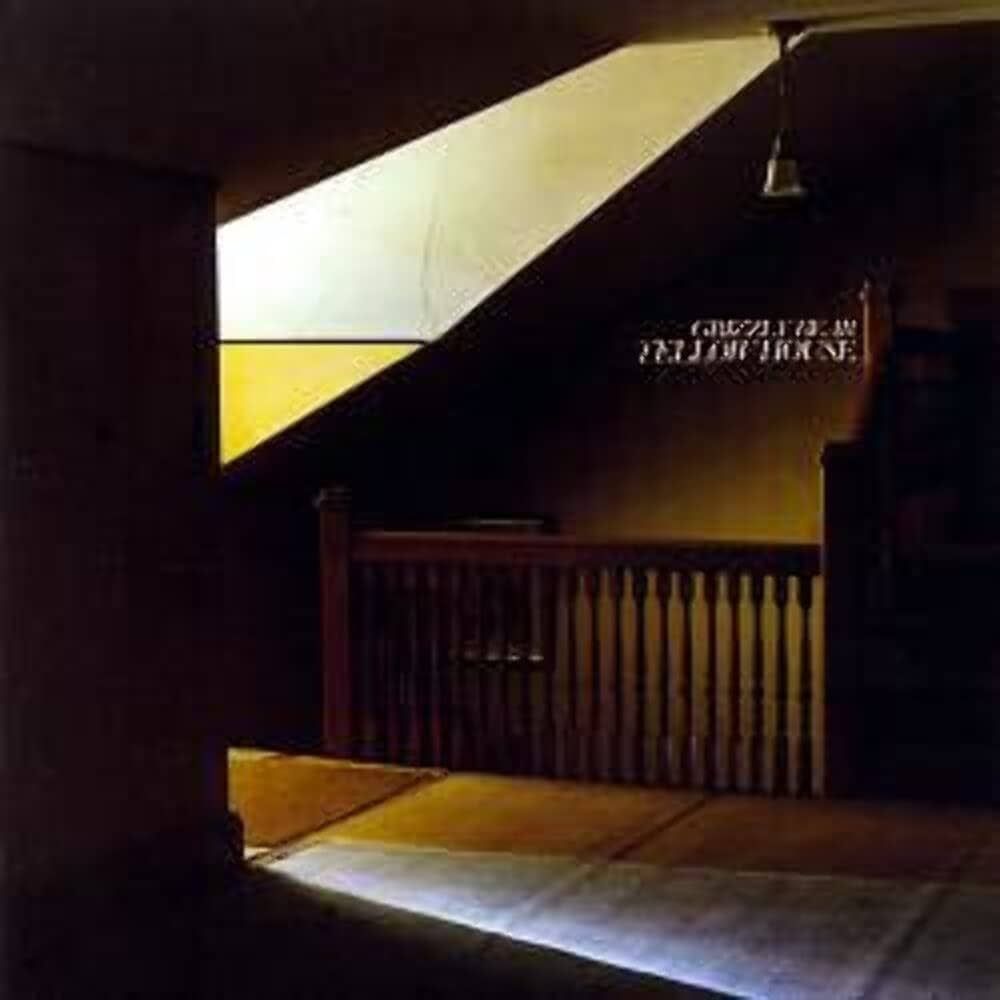 The cover of Grizzly Bear's Yellow House album, showing a dark hallway and top of a stairwell, all tinted in different shades of yellow.