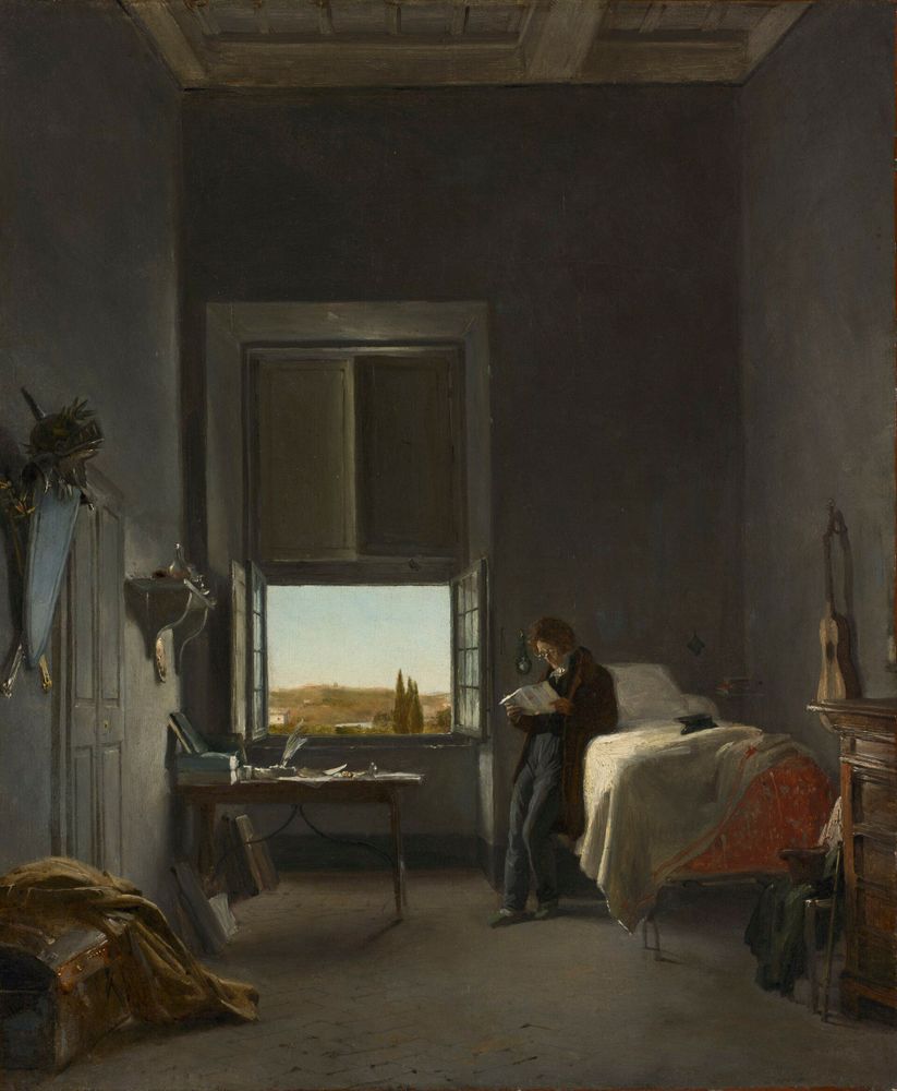 alt-text via GPT — "A 19th century painting depicting a sparse interior room with dark walls and high ceiling. A person in dark clothing stands reading near a bed with white linens. An open window in the center reveals a bright countryside landscape with cypress trees and rolling hills. The room contains a small desk with writing materials, some luggage in the corner, and what appears to be a guitar leaning against the wall. The contrast between the dimly lit interior and the sunlit landscape outside creates a contemplative atmosphere."