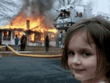 Le meme de la petite fille qui regarde la caméra avec un air narquois avec une maison en feu en arrière plan 
