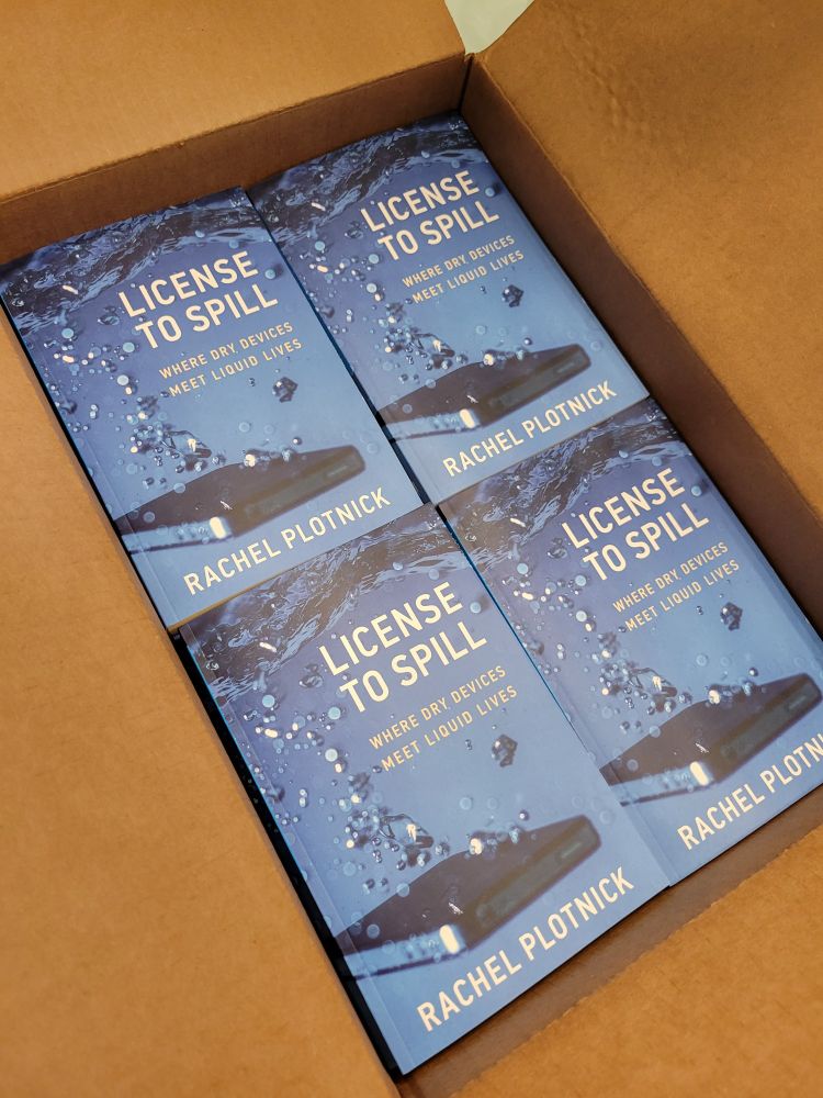 Copies of License to Spill books in a cardboard box.