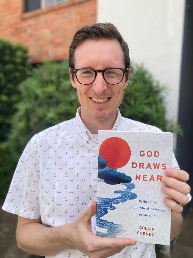 squinting white guy holds colorful book entitled *god draws near*