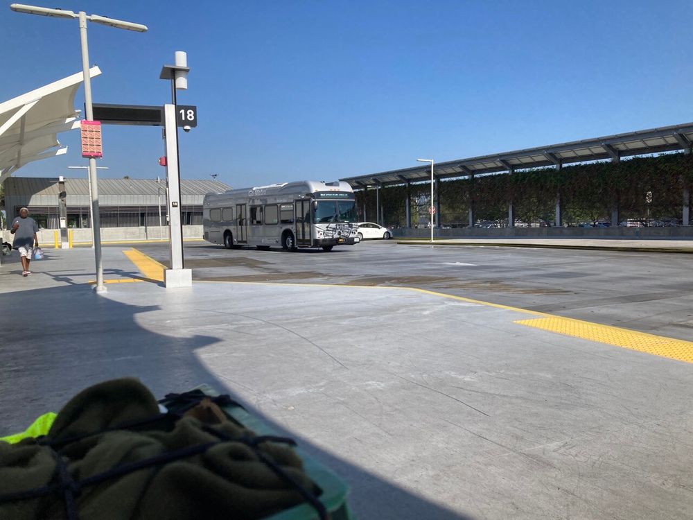 "figure 1: a forty foot bus approaches a boarding bay at el monte j line station. the bus is rectangular in cross section, and has several roof mounted boxes and cowlings"