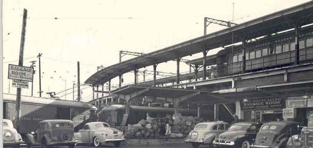 figure 2: a wooden streetcar sits on the bridge above two freight motors at a ground level lot with a baggage room