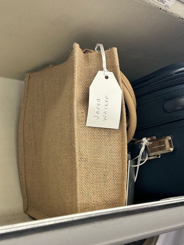 Carry on bag with the label “Jared Walker”.