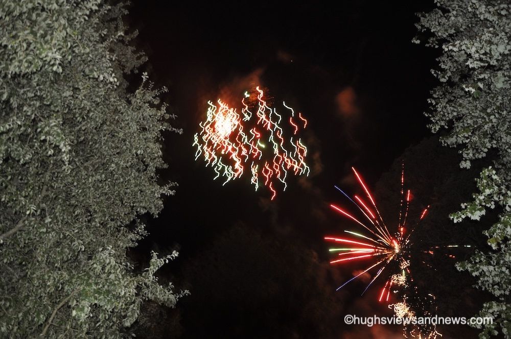 A photo of the night sky with two fireworks exploding showing lots of different colours. 