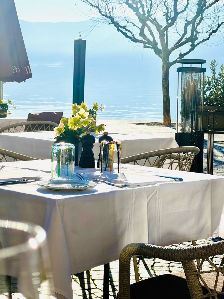 Tisch eingedeckt mit Christrose als Deko! Im Hintergrund der Lago Maggiore